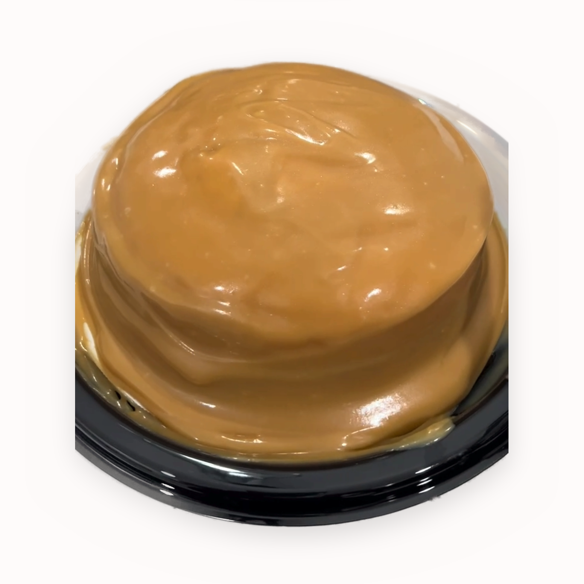 The 2-Layer — a two-layer caramel cake on a black plate, finished with a caramel drip
